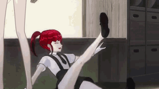 a girl with red hair is sitting on the floor with her leg up .