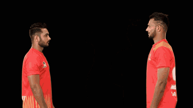 two men wearing red shirts that say ' chennai super kings ' on them are standing next to each other