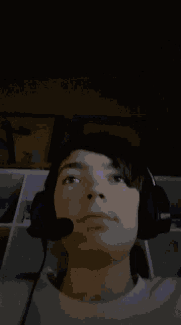 a person wearing headphones and a microphone looks up