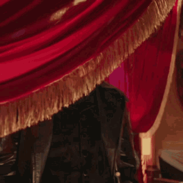 a man in a suit and tie holds up a chandelier