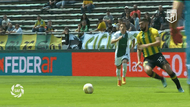 a soccer game is being played in front of a banner that says federal