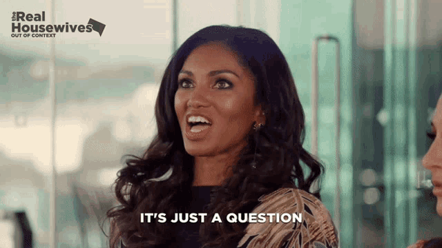 a woman says it 's just a question in front of a real housewives sign