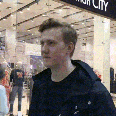 a man wearing a black jacket with the letter w on the front