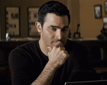 a man with his hand on his chin is looking at a laptop screen