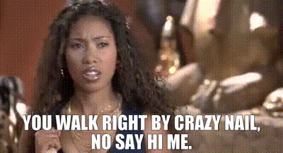 a woman is standing in front of a sign that says you walk right by crazy nail no say hi me .