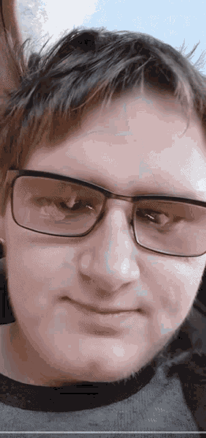 a close up of a man 's face with glasses