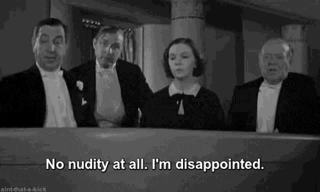 a group of men and women in tuxedos are standing next to each other in a room and talking .