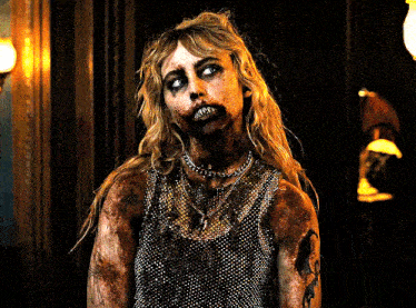 a woman with a chain around her neck is covered in blood
