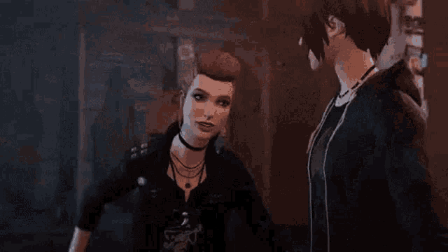 a woman in a black jacket is standing next to a man in a dark room .