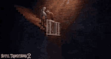 a man is walking up a set of stairs in a dark room with a sign that says hotel transylvania 2 .