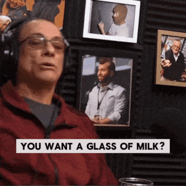 a man wearing headphones is asking if someone wants a glass of milk