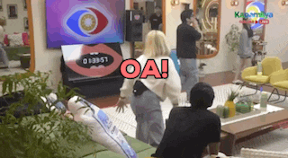 a group of people are standing in a living room in front of a television and a sign that says oa !