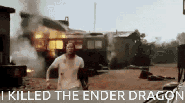a man is running in front of a burning building with the words `` i killed the ender dragon '' written below him .