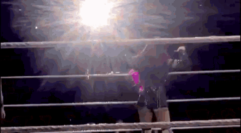 a person in a boxing ring with the sun shining through the ring fence