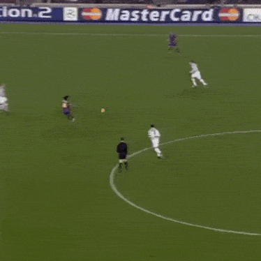 a group of soccer players are playing on a field with a banner for playstation 2 in the background