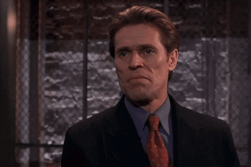 a man in a suit and tie is making a face