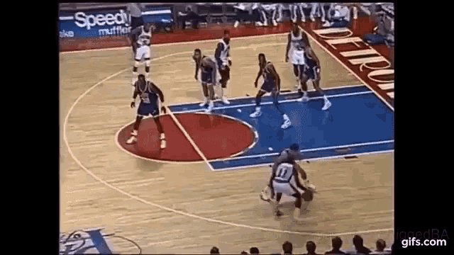 a group of basketball players are playing basketball on a court .