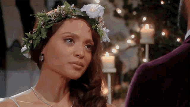 a bride with a flower crown on her head looks at her groom