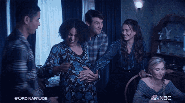 a group of people are gathered around a pregnant woman with the hashtag #ordinary joe