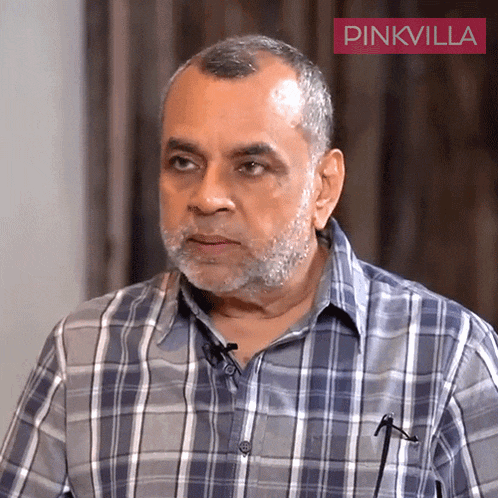 a man with a beard wearing a plaid shirt with a pinkvilla logo in the corner