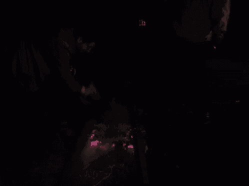 a man is standing in the dark near a fire with a bag of food in his hand