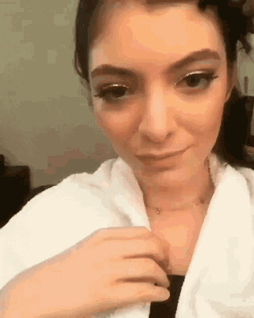 a woman wearing a white robe and a necklace