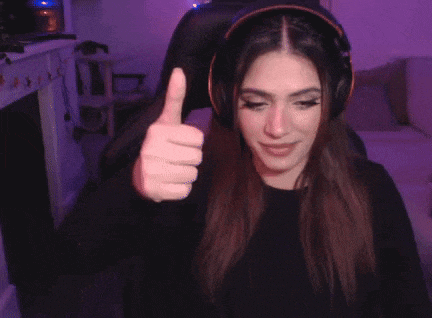 the woman is wearing headphones and giving a thumbs up .