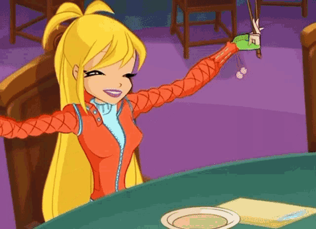 a cartoon girl is sitting at a table holding a green object in her hand