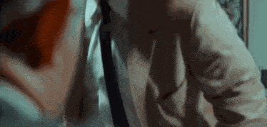 a man in a suit and tie is talking on a phone