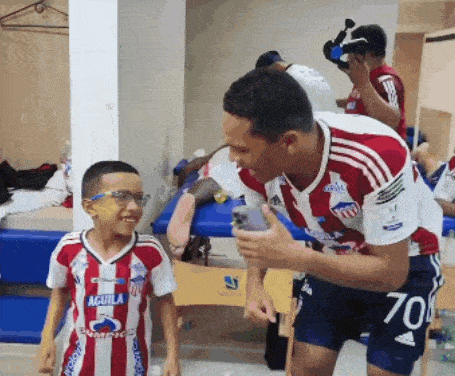 a boy wearing a red and white aguila jersey