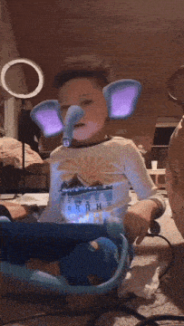 a young boy wearing elephant ears and a shirt that says ' a ' on it