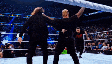 wrestlers in a wrestling ring with a sign that says smack