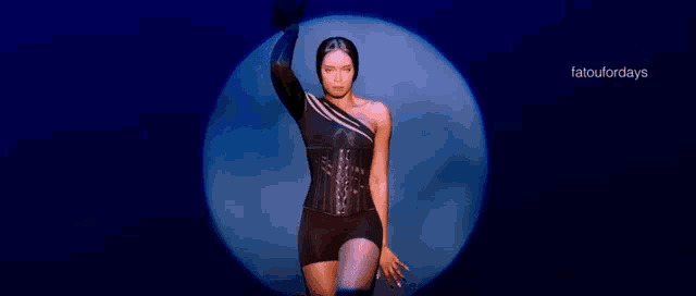 a woman is standing in front of a blue circle with the words fatoufordays on the bottom right