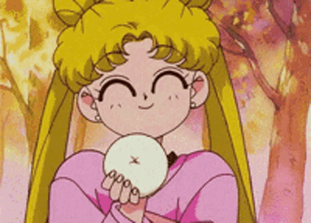 a girl in a pink shirt is holding a white object with a x on it