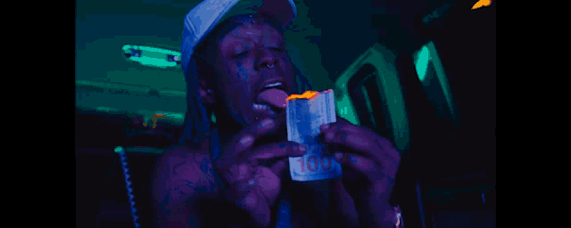 a man with dreadlocks is sticking his tongue out while talking into a phone