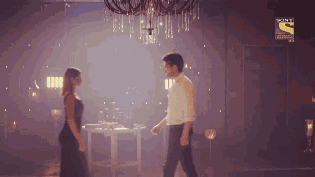 a man and a woman are dancing in a dark room with a sony logo in the corner