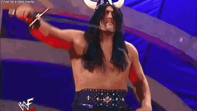 a man with long hair is standing in front of a blue sign that says smackdown