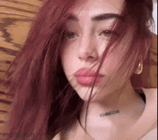 a woman with red hair and a tattoo on her neck .