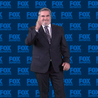 a man in a suit is standing in front of a fox deportes wall