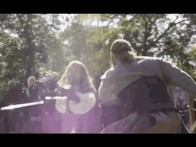 a woman is playing a guitar and a man is playing drums in a park .