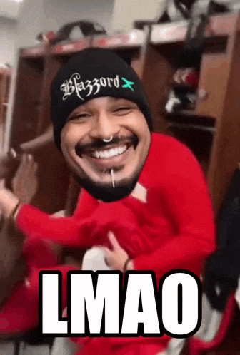 a man wearing a beanie and a red shirt with the word lmao on it