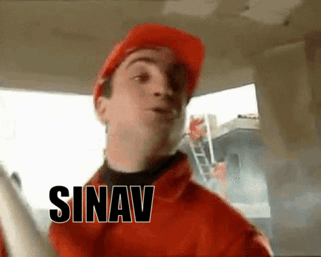 a man wearing a hard hat and a red jacket with the word sinav above him