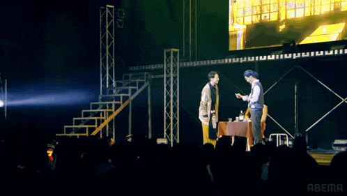 a group of people standing in front of a screen that says abema on it