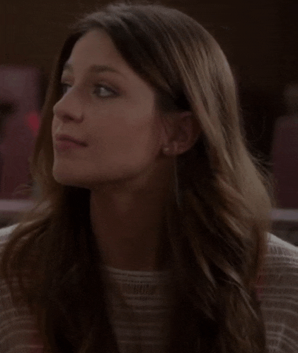 a close up of a woman 's face with long hair and earrings