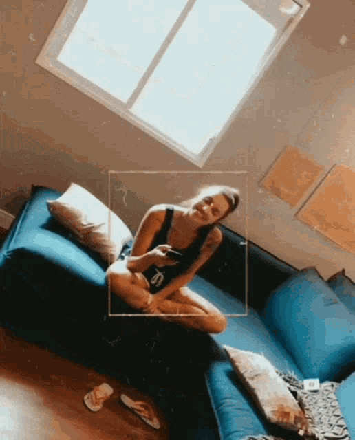 a woman is sitting on a blue couch with a square around her
