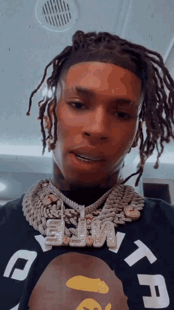 a man with dreadlocks is wearing a t-shirt that says tf on it