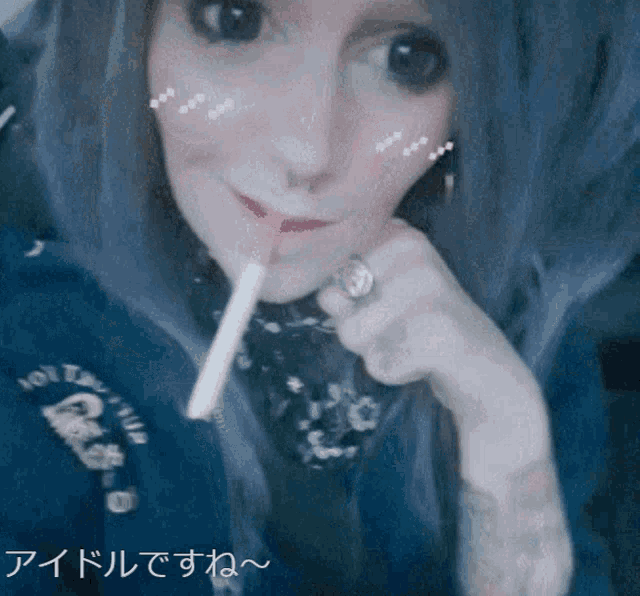a woman with a cigarette in her mouth is wearing a hoodie that says hollywood