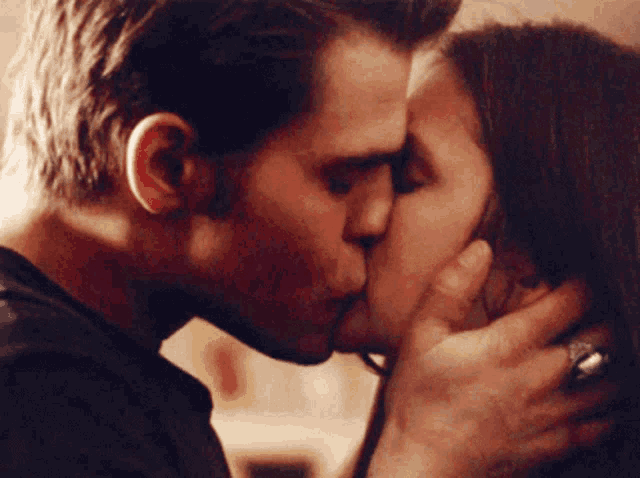 a man and a woman kissing with a ring on her finger