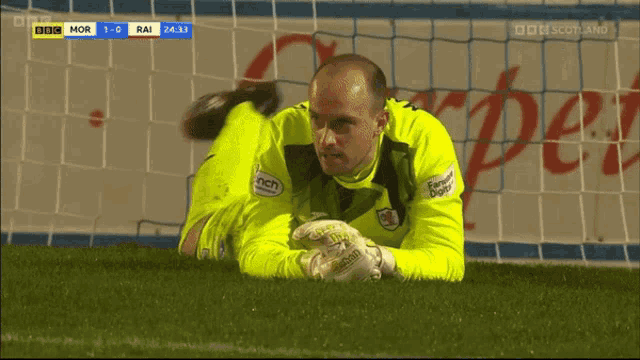 a soccer goalie is laying on the field with bbc scotland on the bottom right