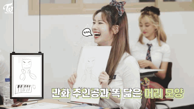 a girl laughs while holding a drawing in front of a sign that says " twice "